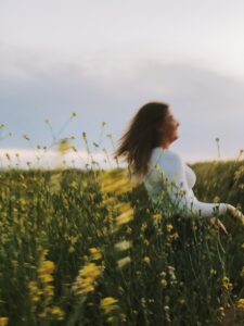 A blurry photo of a girl dancing among the grass